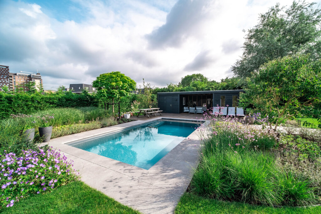 Tuin met luxe zwembad en moderne beplanting, aangelegd door een deskundige hovenier.